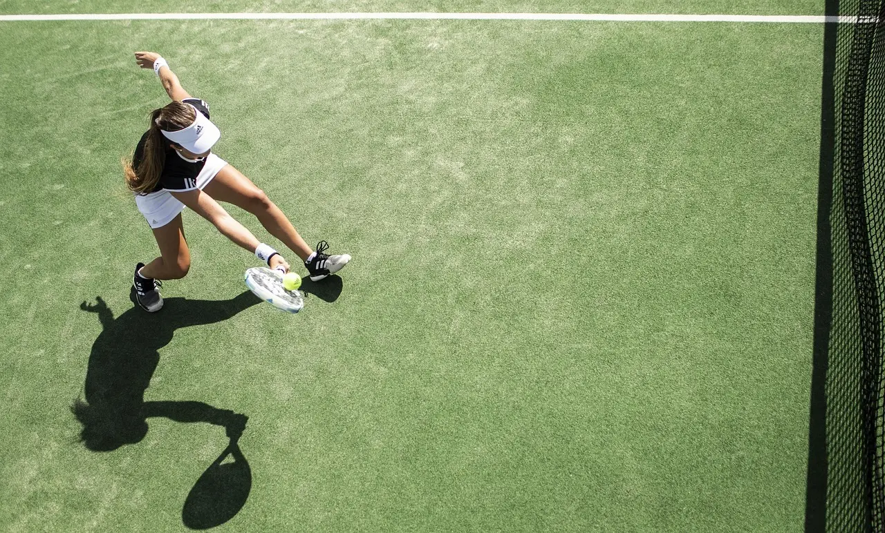Tennisspiller set ovenfra ved nettet på en grøn bane